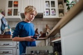 Boy helping to load dishwasher after breakfast. Cleaning the kitchen before leaving to school - PhotoDune Item for Sale