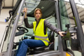 Female warehouse worker driving forklift. Warehouse worker preparing products for shipmennt - PhotoDune Item for Sale