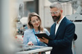 Female engineer and male production manager standing in modern industrial factory, talking about - PhotoDune Item for Sale