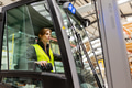Female warehouse worker driving forklift. Warehouse worker preparing products for shipmennt - PhotoDune Item for Sale