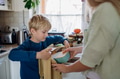 Mom packing snack for her son for school. Putting lunch box with healthy snack into his school bag - PhotoDune Item for Sale