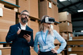 Warehouse managers talking logistics using VR, controlling stock levels. Virtual reality in - PhotoDune Item for Sale