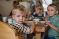 Little baby eating breakfast in high chair in home kitchen. Healthy breakfast or snack before day - PhotoDune Item for Sale