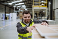 Portrait of young man with Down syndrome working in warehouse. Concept of workers with disabilities - PhotoDune Item for Sale