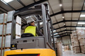 Female warehouse worker driving forklift. Warehouse worker preparing products for shipmennt - PhotoDune Item for Sale