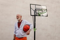 Senior man playing basketball outdoors on basketball court in city. Older, vital man has active - PhotoDune Item for Sale