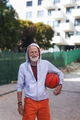 Senior man playing basketball outdoors on basketball court in city. Older, vital man has active - PhotoDune Item for Sale