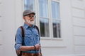 Portrait of handsome senior man in the city. Elderly independent man with backpack visiting new city - PhotoDune Item for Sale
