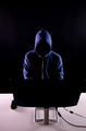 Anonymous and faceless hacker under hoodie using computer isolated over dark background - PhotoDune Item for Sale
