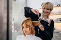 Young female hairstylist trimming customer hair - PhotoDune Item for Sale