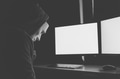Masked hacker under hood using computer to hack into system and trying to commit computer crime - PhotoDune Item for Sale