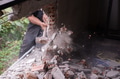 Unrecognizable builder using a sledgehammer breaking and smashing the wall fallen into debris - PhotoDune Item for Sale