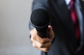 Man in business suit holding a microphone - PhotoDune Item for Sale