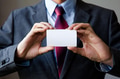 Young man in business suit holding white blank business card - PhotoDune Item for Sale