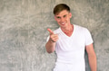 Young man with happy and friendly smile pointing finger at camera - PhotoDune Item for Sale