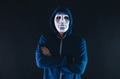 Anonymous masked man under hoodie with arms crossed isolated over dark background - PhotoDune Item for Sale