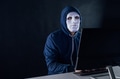 masked hacker under hoodie using computer - PhotoDune Item for Sale