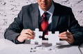 Hands of business man working on finishing last missing pieces of jigsaw - PhotoDune Item for Sale