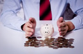 Businessman putting hands together to protect money piggy bank - PhotoDune Item for Sale