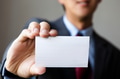 Young man in business suit holding white blank business card - PhotoDune Item for Sale