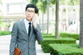 Young Asian businessman in elegant suit talking on the phone with serious face - PhotoDune Item for Sale