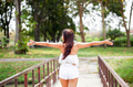 Young woman spreading her arms in green park - freedom and travel concept (selective focus) - PhotoDune Item for Sale