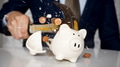 businessman using a hammer to smash plenty of coins inside piggybank into pieces - PhotoDune Item for Sale