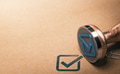 Check mark and rubber stamp over paper background with copy space on le left. - PhotoDune Item for Sale