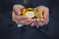 Close-up of businessman's hands full of cryptocurrency coins - PhotoDune Item for Sale