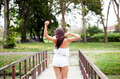 Young woman spreading her arms in green park - freedom and travel concept (selective focus) - PhotoDune Item for Sale