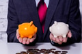 Businessman making a comparison and difference between each money piggy bank - PhotoDune Item for Sale
