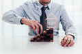 Close up of businessman using hand to climb up a stack of blocks towards house model - PhotoDune Item for Sale