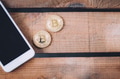 Two coins of Crypto currency Bitcoin with smart phone with copy space - PhotoDune Item for Sale