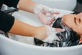 Hairdresser shampooing hair of female customer - PhotoDune Item for Sale
