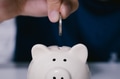 Close up of human hands putting and inserting coin into money piggy bank - PhotoDune Item for Sale