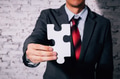 Business man giving the missing piece of jigsaw as offering a success - PhotoDune Item for Sale