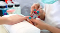 Close-up of woman hands at beauty salon receiving a manicure and nail care process by manicurist - PhotoDune Item for Sale
