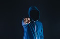faceless man under hoodie pointing finger at camera isolated over dark background - PhotoDune Item for Sale