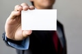 Young man in business suit holding white blank business card - PhotoDune Item for Sale