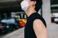 Young man showing arms with bandage after Covid-19 vaccine injection - PhotoDune Item for Sale
