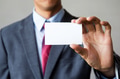 Young man in business suit holding white blank business card - PhotoDune Item for Sale