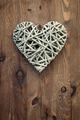 Reed heart hanging against a rustic wooden background. - PhotoDune Item for Sale