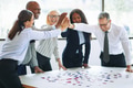 Laughing businesspeople high fiving together while solving a jigsaw puzzle - PhotoDune Item for Sale
