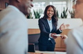 Laughing young African American hotel concierge helping guests check in - PhotoDune Item for Sale