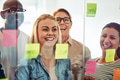 Diverse businesspeople laughing together while brainstorming with sticky notes - PhotoDune Item for Sale