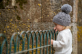Cute blonde kid in a gray hat exploring the world around him in a park. - PhotoDune Item for Sale