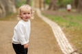 Interested caucasian baby boy alone on a sidewalk on a chilly day. A boy in a white sweater - PhotoDune Item for Sale