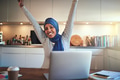 Young Arabic woman ecstatically celebrating her business success at home - PhotoDune Item for Sale