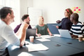 Group of designers smiling while working around an office table - PhotoDune Item for Sale
