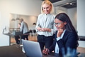Smiling businesswomen working over a laptop together in an office - PhotoDune Item for Sale